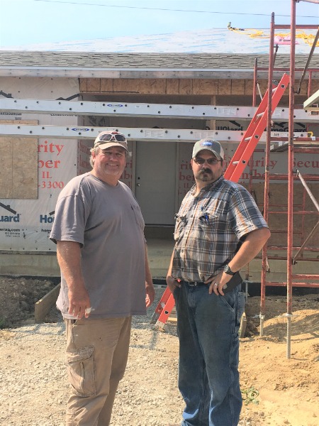 Jeff Umprey on left, standing with Andrew Kelson at the construction site of KACC House 22.